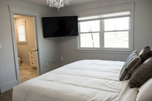 A cozy bedroom featuring a comfortable bed and a television, creating a relaxing atmosphere for leisure and rest