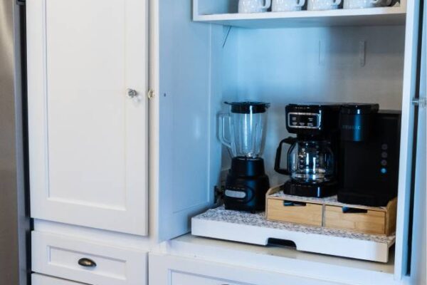 A modern kitchen featuring a sleek refrigerator and a stylish coffee maker on the countertop