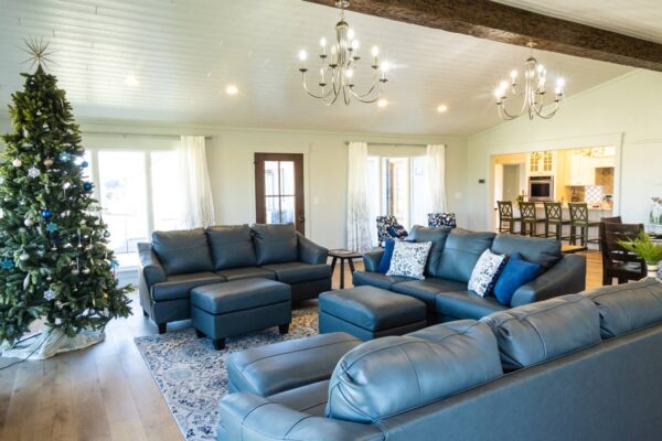 A warm living room scene showcasing plush couches and a vibrant Christmas tree, perfect for holiday gatherings