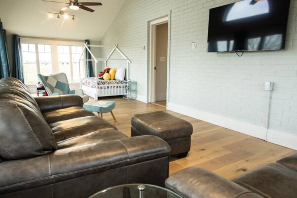 Elegant living room showcasing leather seating and a sleek flat-screen television, perfect for relaxation and entertainment